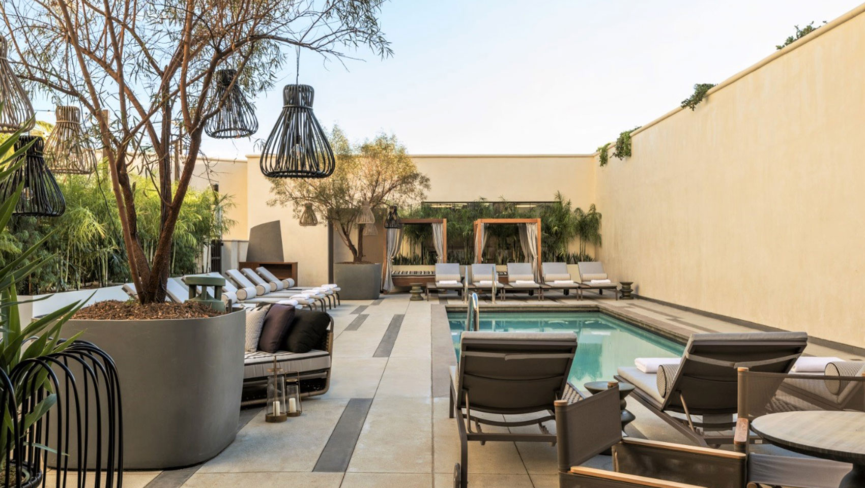 View of pool seating with chairs, umbrellas and cabanas