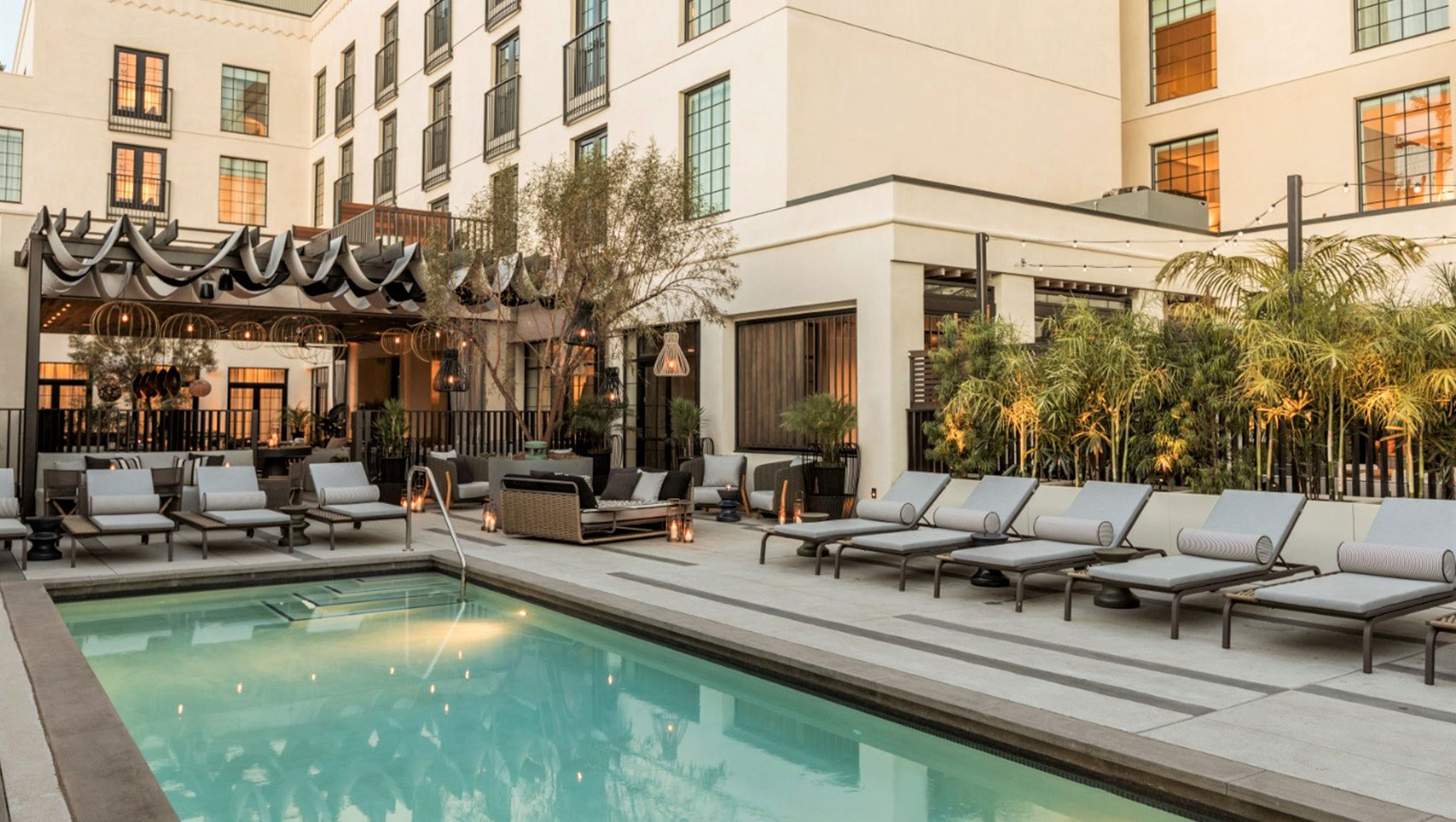 View of pool at dusk with poolside seating